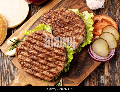 Cotolette di carne fresca su sfondo di legno Foto Stock