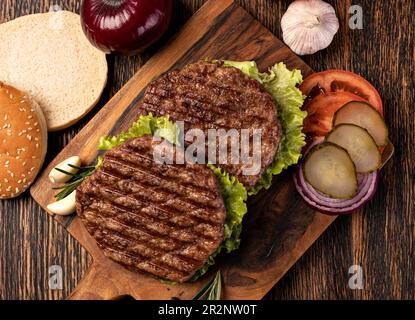 Cotolette di carne fresca su sfondo di legno Foto Stock
