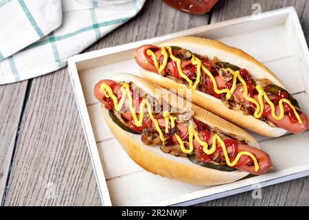 Hot dog grigliato con senape gialla e ketchup su tavolo di legno Foto Stock