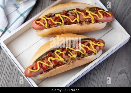 Hot dog grigliato con senape gialla e ketchup su tavolo di legno Foto Stock