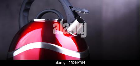 Composizione con bollitore in acciaio inox rosso con fischio Foto Stock