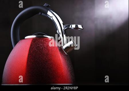 Composizione con bollitore in acciaio inox rosso con fischio Foto Stock