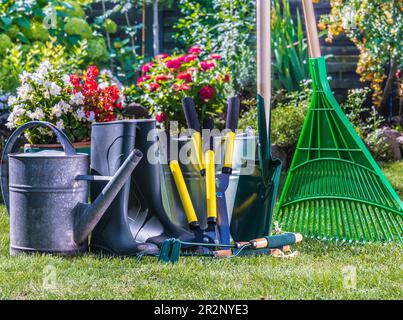 Attrezzi da giardinaggio sull'erba nel giardino Foto Stock