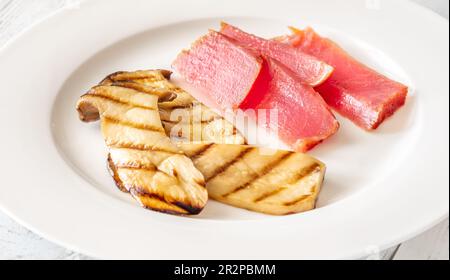 Porzione di eryngii alla griglia con tonno a fette Foto Stock