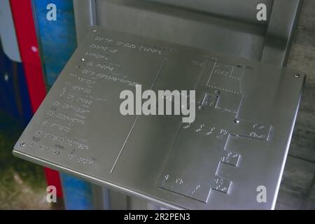 Stativo in argento con testo Braille e piano di costruzione al coperto, primo piano Foto Stock