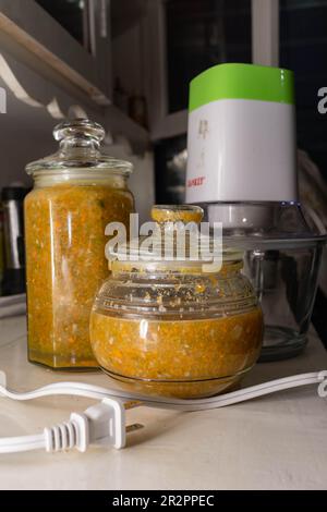 Chilero, un tipo di salsa nicaraguana fatta da peperoni, cipolle e carote di Jalepeno, in due contenitori di vetro in da un tritatutto vegetale elettrico. Foto Stock