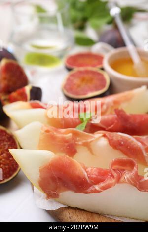 Gustosi meloni, jamon e fichi serviti sul tavolo, primo piano Foto Stock