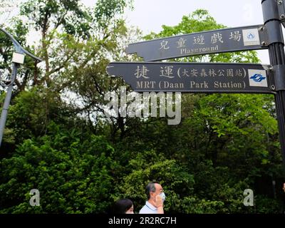 Cartello bilingue cinese inglese al Daan Park che indica il parco giochi e la stazione MRT; Taipei, Taiwan. Foto Stock