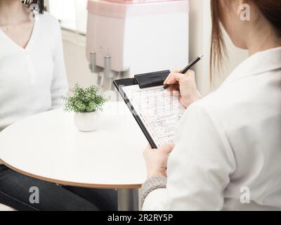 Donna giapponese che riceve consulenza Foto Stock