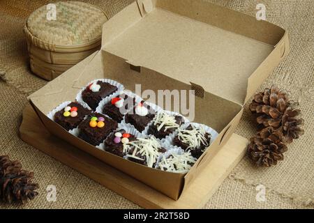 Brownie al cioccolato in una scatola con vari condimenti Foto Stock
