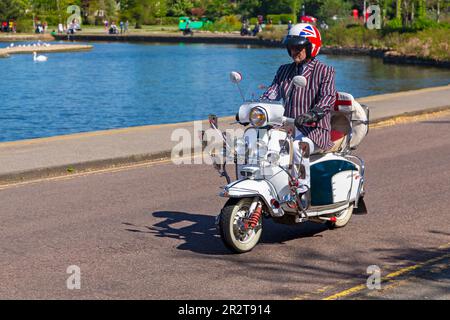 Poole, Dorset, Regno Unito. 21 maggio 2023 Bournemouth and Poole Distinguished Gentlemen's Ride è un evento annuale, uno dei tanti in tutto il mondo, per raccogliere fondi e sensibilizzare sulla salute degli uomini. Durante il loro viaggio, centinaia di moto, molte vintage, attraversano Poole Park sulla strada per Bournemouth con molti dei loro piloti vestiti in modo appropriato, in stile retrò cravatte, baffi e tweeds in una bella giornata di sole. Crediti: Carolyn Jenkins/Alamy Live News Foto Stock