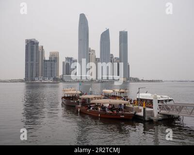 Vista dal Dubai creek del lungomare di al Jaddaf con i taxi fluviali nel Dubai Creek e i grattacieli di al Jaddaf dall'altra parte dell'acqua Foto Stock