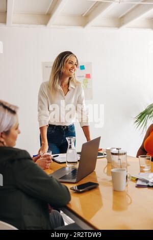 Buon responsabile del team che ha avuto un incontro con i colleghi in un ufficio. Gruppo di creative donne d'affari brainstorming in una sala riunioni. Business wom diversificato Foto Stock
