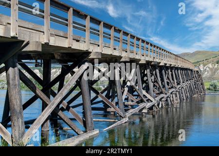 Vista dal basso angolo a livello del fiume del ponte in legno di Pritchard sul fiume Thompson, Pritchard, Canada, un tipo di ponte a ringhiera Foto Stock