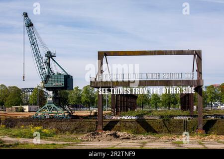 Gru e l'installazione d'arte Vedi le cose dall'altra parte di Tim Etchells su un vecchio ponte di carico nel porto del Reno Deutz, Colonia, Germania. KR Foto Stock