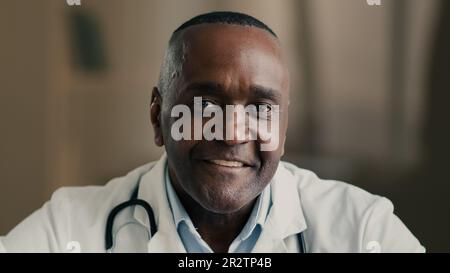 Ritratto medico di medico terapeuta anziano maschio medico afroamericano uomo oculista ginecologo oftalmologo medico generale senior si siede Foto Stock