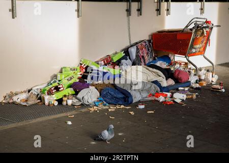 Senzatetto con i suoi possedimenti e un sacco di spazzatura si trova in via Caecilien nel centro della città, sotto una zona coperta del marciapiede, Colonia, GE Foto Stock