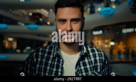 Gioioso uomo felice sopportato 30s tipo riuscito uomo d'affari elegante proprietario di affari di shopper che posa nel centro commerciale moderno sorridente allegro positivo Foto Stock