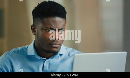 Arrabbiato uomo infastidito african businessman boss parlare in video conferenza utilizzare computer litigare conflitto contestare cattivo servizio parlando lontano grido Foto Stock