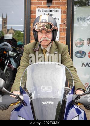 Warrington, Cheshire, Regno Unito. 21st maggio, 2023. UK - il Gentleman's Ride (DGR) unisce motociclisti classici e vintage da tutto il mondo per raccogliere fondi e consapevolezza per la ricerca sul cancro alla prostata e la salute mentale degli uomini. Un gruppo di motociclisti provenienti da Warrington vestito con le loro migliori tute e cravatte, si è incontrato presso il concessionario di motociclette locale e poi ha attraversato il centro della città prima di uscire dalla città e attraverso una combinazione di villaggi e città. Finirono al centro visitatori della Jodrell Bank. Credit: John Hopkins/Alamy Live News Foto Stock