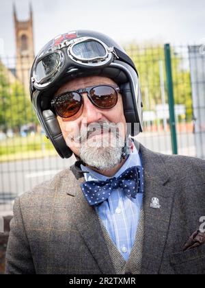 Warrington, Cheshire, Regno Unito. 21st maggio, 2023. UK - il Gentleman's Ride (DGR) unisce motociclisti classici e vintage da tutto il mondo per raccogliere fondi e consapevolezza per la ricerca sul cancro alla prostata e la salute mentale degli uomini. Un gruppo di motociclisti provenienti da Warrington vestito con le loro migliori tute e cravatte, si è incontrato presso il concessionario di motociclette locale e poi ha attraversato il centro della città prima di uscire dalla città e attraverso una combinazione di villaggi e città. Finirono al centro visitatori della Jodrell Bank. Credit: John Hopkins/Alamy Live News Foto Stock