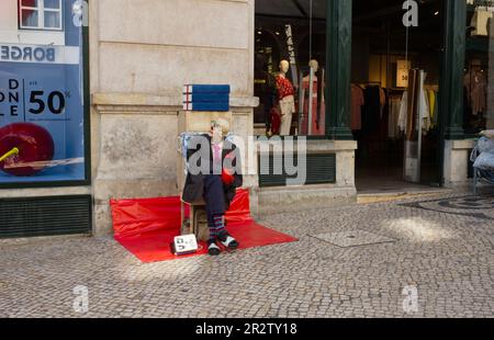 Un artista mimo nel centro delle trafficate strade dello shopping di Lisbona Foto Stock