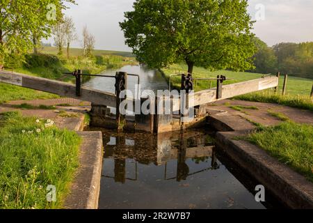 Blocca e blocca i cancelli a Tyrley Locks sul canale Shropshire Union in Inghilterra. Alberi riflessi in acqua ferma in una mattina di sole Foto Stock