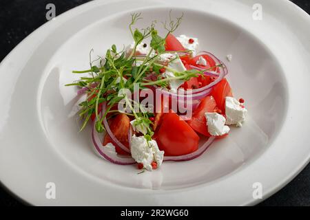 insalata di primavera colorata con pomodori maturi, feta, cipolle e microgreens Foto Stock