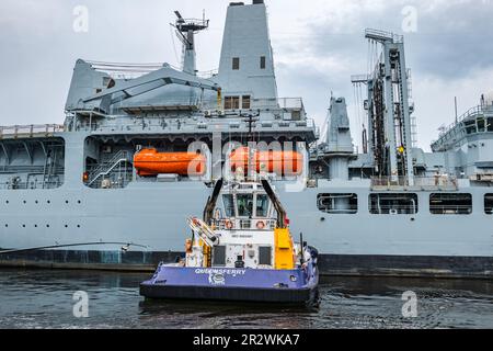 RFA Forth Victoria nave navale (A387) spinto da un rimorchiatore a Leith porto banchine, Edimburgo, Scozia, Regno Unito Foto Stock