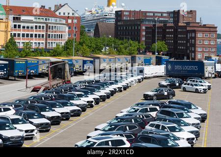 Am Parkplatz des Schwedenkais Warten Neuwagen und LKW-Auflieger auf Verladung auf der Schwedenfähre Foto Stock