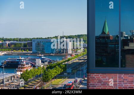 Am Ende der Kieler Förde das Gebäude des Hörn Campus, davor Gleisanlagen und Fördeschiffe. Imrechten Bereich Siegelung der Kieler Innenstadt in einer Foto Stock