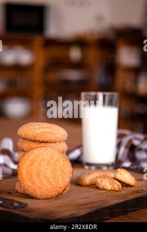 Biscotti fatti in casa con un bicchiere di latte su un asse di legno. Torte fatte in casa Foto Stock