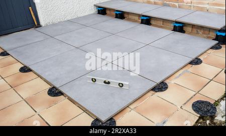 Pavimenti esterni pavimento pavimento installazione terrazza e piazzole regolabili bottoni in plastica con livella a bolla Foto Stock