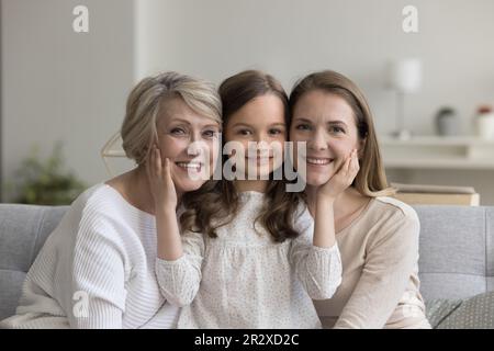 Bambina in posa per la macchina fotografica con nonna e madre Foto Stock