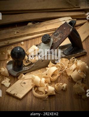 Piallatrice e trucioli dopo la piallatura di tavole di legno. Foto Stock