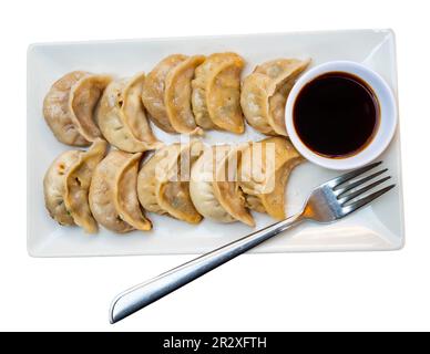 Per pranzo viene servito un piatto di gnocchi cinesi fritti e una ciotola di salsa di soia Foto Stock