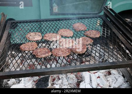 Hamburger di manzo su una griglia durante un festival di cibo Foto Stock