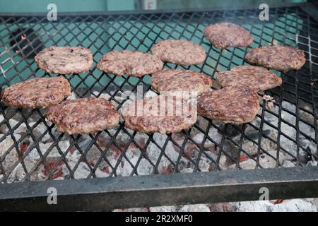 Hamburger di manzo su una griglia durante un festival di cibo Foto Stock