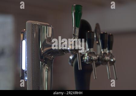 Primo piano sui rubinetti di birra di fila. Foto Stock