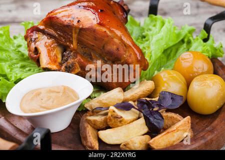 Appetitosa articolazione di maiale arrosto sul tagliere Foto Stock