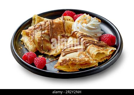 piatto di crepes appena sfornate con crema e frutti di bosco isolati su fondo bianco Foto Stock