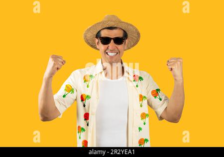 Uomo latino in vacanza indossando hawaian camicia cappello occhiali da sole estate su sfondo giallo isolato molto felice ed eccitato facendo gesto vincitore con il braccio Foto Stock