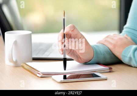 Donna d'affari in attesa di una chiamata telefonica in ufficio Foto Stock