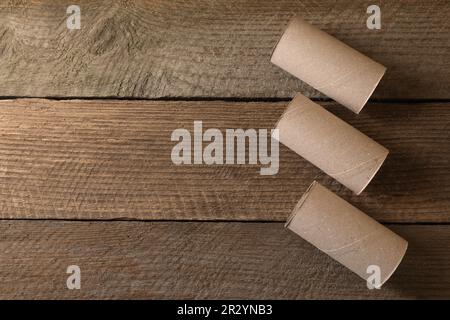 Rotoli di carta igienica vuoti su tavolo di legno, piatto. Spazio per il testo Foto Stock