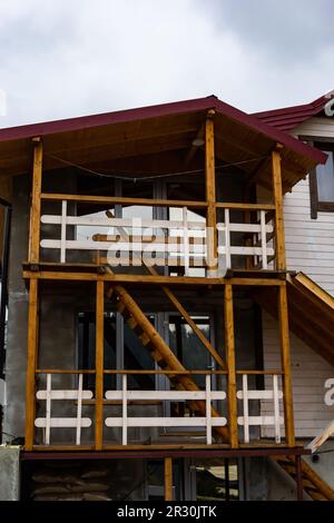 Bella sala terrazza moderna, una grande terrazza in legno in una casa di legno con una foresta intorno. Natura e concetto di vacanza. Foto Stock