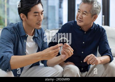 Uomo cinese medio adulto che ammira l'antiquariato con suo padre Foto Stock