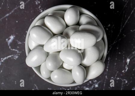 Drago al cioccolato e alle mandorle. Drago al cioccolato in ciotola di ceramica su sfondo scuro. Vista dall'alto Foto Stock