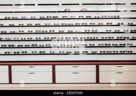 Stativo con occhiali da sole. Vendere il mercato cittadino o nel negozio. Occhiali estivi, collezione moda. Occhiali da sole diversi su un piedistallo. Foto Stock