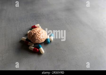 Pillole colorate e cervello con spazio di copia per il testo. Malattia mentale, malattia del cervello e concetto di salute mentale. Foto Stock