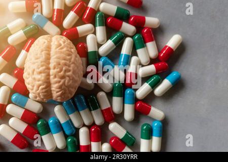 Pillole colorate e cervello con spazio di copia per il testo. Malattia mentale, malattia del cervello e concetto di salute mentale. Foto Stock